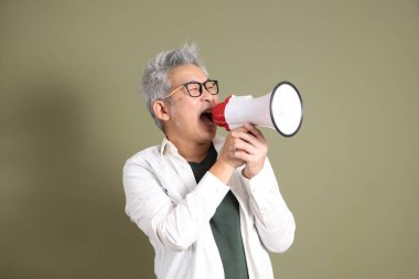 Doğu Asyalı bir işadamının yarım vücut portresi. Koyu yeşil bir arka planda izole edilmiş. Stüdyoda çekilmiş..