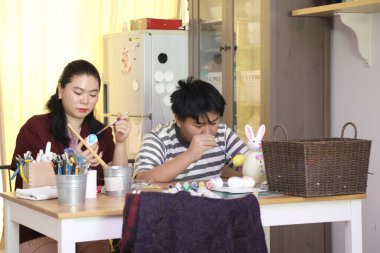 Doğu Asyalı bekar anne ve oğlu Paskalya için yumurta boyuyor..