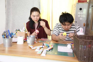 Doğu Asyalı bekar anne ve oğlu Paskalya için yumurta boyuyor..