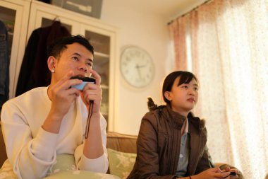 İki arkadaş oturma odasında oyun oynayıp eğleniyorlar..