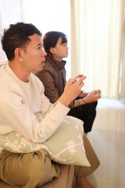 İki arkadaş oturma odasında oyun oynayıp eğleniyorlar..