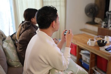 İki arkadaş oturma odasında oyun oynayıp eğleniyorlar..