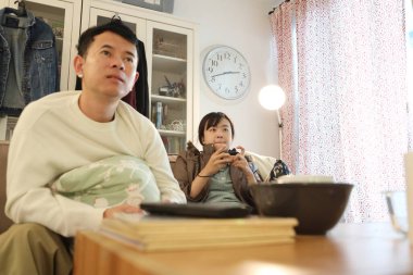 İki arkadaş oturma odasında oyun oynayıp eğleniyorlar..