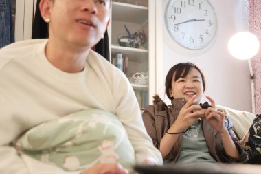 İki arkadaş oturma odasında oyun oynayıp eğleniyorlar..