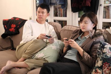 İki arkadaş oturma odasında oyun oynayıp eğleniyorlar..