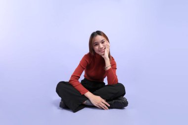 The young Southeast Asian woman in casual clothes, standing against a purple background. clipart