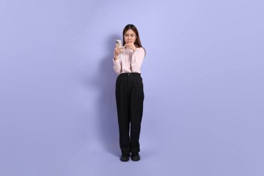 A young Southeast Asian woman in business clothes, standing against a purple background. clipart