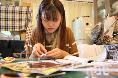 Doğu Asyalı kadın oturma odasında plastik bir oyuncak monte ediyor..