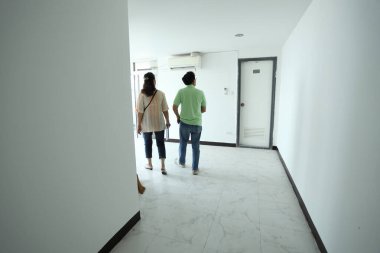 Doğu Asyalı üst düzey bir çift, satmadan önce tadilattan sonra daireyi kontrol ediyor..