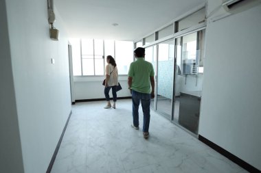 Doğu Asyalı üst düzey bir çift, satmadan önce tadilattan sonra daireyi kontrol ediyor..