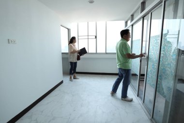 Doğu Asyalı üst düzey bir çift, satmadan önce tadilattan sonra daireyi kontrol ediyor..