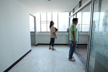 Doğu Asyalı üst düzey bir çift, satmadan önce tadilattan sonra daireyi kontrol ediyor..