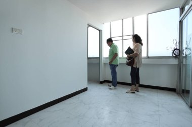 Doğu Asyalı üst düzey bir çift, satmadan önce tadilattan sonra daireyi kontrol ediyor..