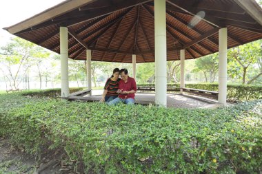 Doğu Asya 'nın son sınıf çifti parkta oturmuş dinleniyor..