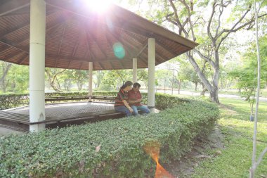 Doğu Asya 'nın son sınıf çifti parkta oturmuş dinleniyor..