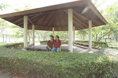 Doğu Asya 'nın son sınıf çifti parkta oturmuş dinleniyor..