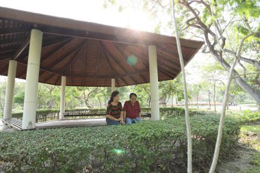 Doğu Asya 'nın son sınıf çifti parkta oturmuş dinleniyor..