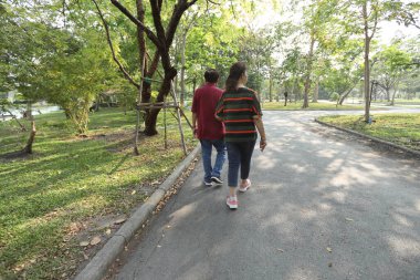 Doğu Asya 'nın son sınıf çifti parkta yürüyor.