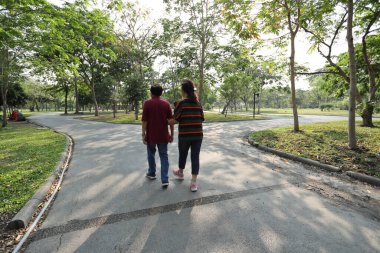 Doğu Asya 'nın son sınıf çifti parkta yürüyor.