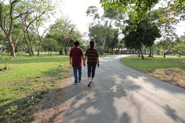 Doğu Asya 'nın son sınıf çifti parkta yürüyor.