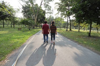 Doğu Asya 'nın son sınıf çifti parkta yürüyor.