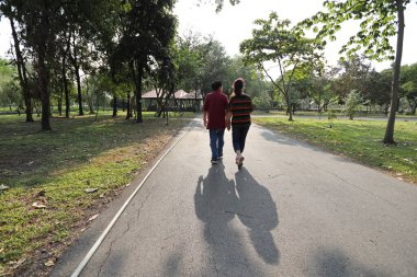 Doğu Asya 'nın son sınıf çifti parkta yürüyor.