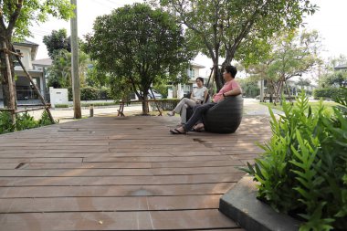 Doğu Asyalı çift parkta oturuyor ve dinleniyorlar..