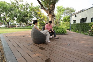 Doğu Asyalı çift parkta oturuyor ve dinleniyorlar..