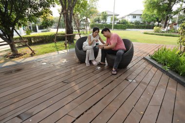 Doğu Asyalı çift parkta oturuyor ve dinleniyorlar..
