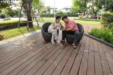 Doğu Asyalı çift parkta oturuyor ve dinleniyorlar..