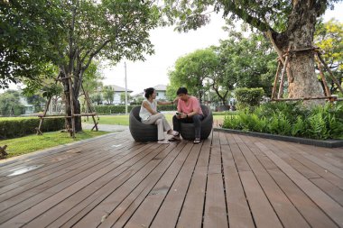 Doğu Asyalı çift parkta oturuyor ve dinleniyorlar..