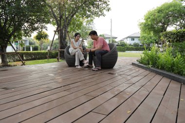 Doğu Asyalı çift parkta oturuyor ve dinleniyorlar..