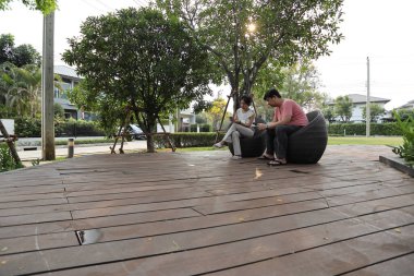 Doğu Asyalı çift parkta oturuyor ve dinleniyorlar..