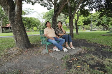 Doğu Asyalı çift parkta oturuyor ve dinleniyorlar..