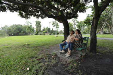 Doğu Asyalı çift parkta oturuyor ve dinleniyorlar..