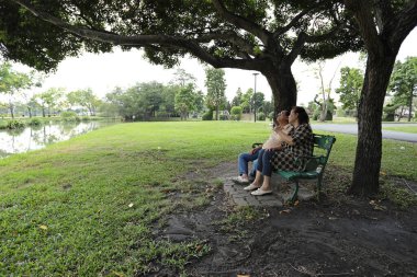 Doğu Asyalı çift parkta oturuyor ve dinleniyorlar..