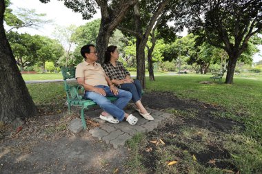 Doğu Asyalı çift parkta oturuyor ve dinleniyorlar..