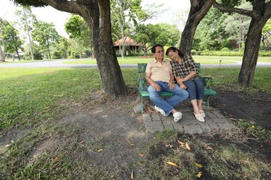 Doğu Asyalı çift parkta oturuyor ve dinleniyorlar..