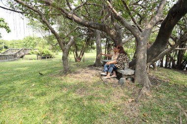 Doğu Asyalı çift parkta oturuyor ve dinleniyorlar..