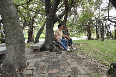 Doğu Asyalı çift parkta oturuyor ve dinleniyorlar..