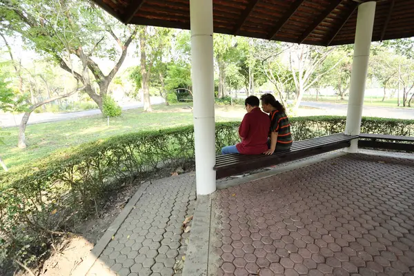 Doğu Asya 'nın son sınıf çifti parkta oturmuş dinleniyor..