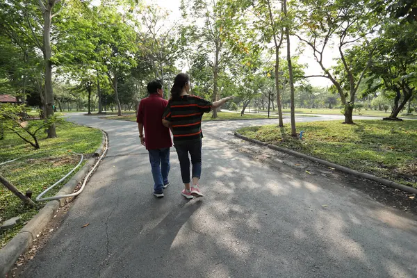 Doğu Asya 'nın son sınıf çifti parkta yürüyor.