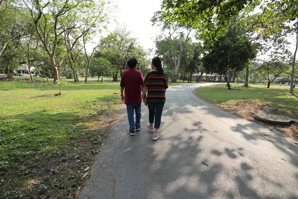 Doğu Asya 'nın son sınıf çifti parkta yürüyor.