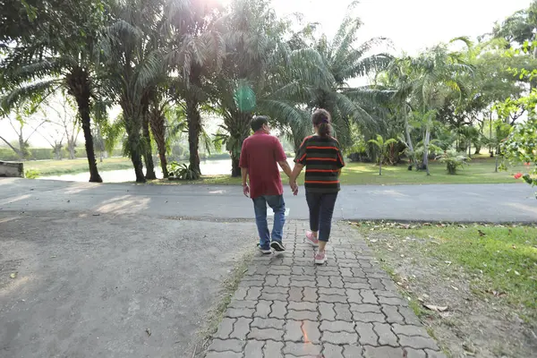 Doğu Asya 'nın son sınıf çifti parkta yürüyor.