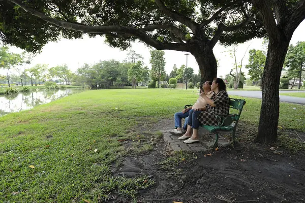 Doğu Asyalı çift parkta oturuyor ve dinleniyorlar..