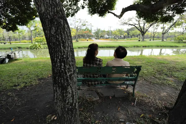 Doğu Asyalı çift parkta oturuyor ve dinleniyorlar..