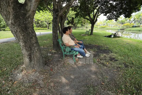 Doğu Asyalı çift parkta oturuyor ve dinleniyorlar..