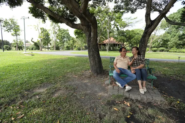 Doğu Asyalı çift parkta oturuyor ve dinleniyorlar..