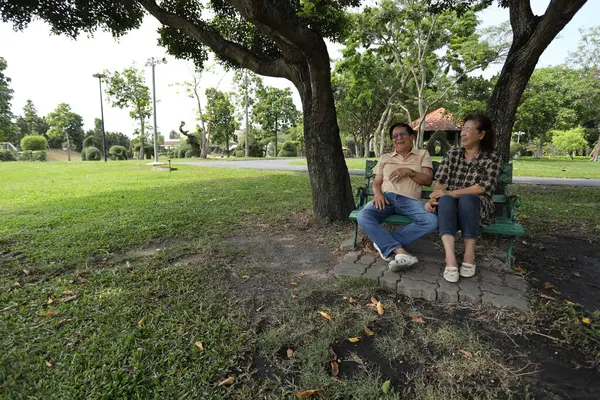 Doğu Asyalı çift parkta oturuyor ve dinleniyorlar..