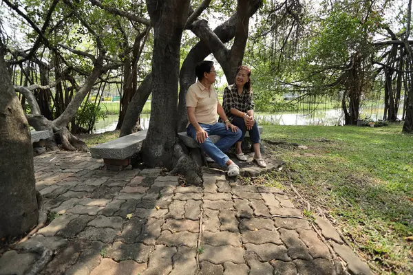 Doğu Asyalı çift parkta oturuyor ve dinleniyorlar..